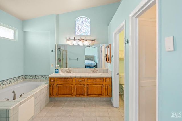 full bath featuring a garden tub, a stall shower, a sink, connected bathroom, and tile patterned flooring