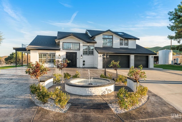 view of front of home with curved driveway, a garage, roof with shingles, and stucco siding
