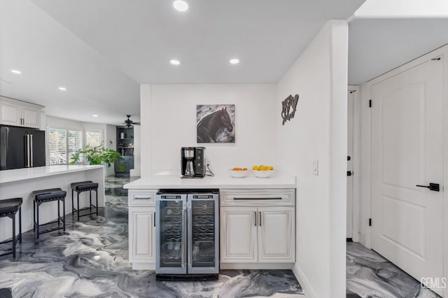 bar with beverage cooler, marble finish floor, recessed lighting, a bar, and high end black refrigerator