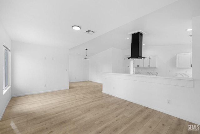 unfurnished living room with plenty of natural light, lofted ceiling, and light wood-type flooring