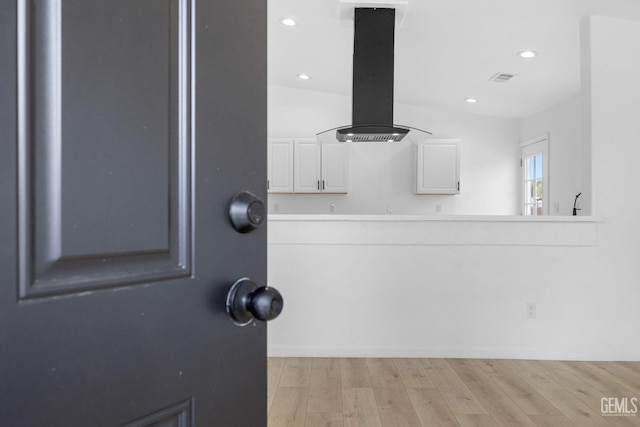 room details featuring island range hood and hardwood / wood-style flooring