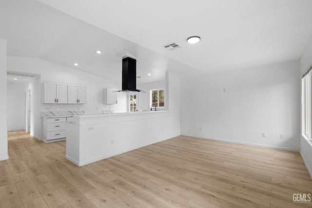 unfurnished living room with light hardwood / wood-style floors and vaulted ceiling