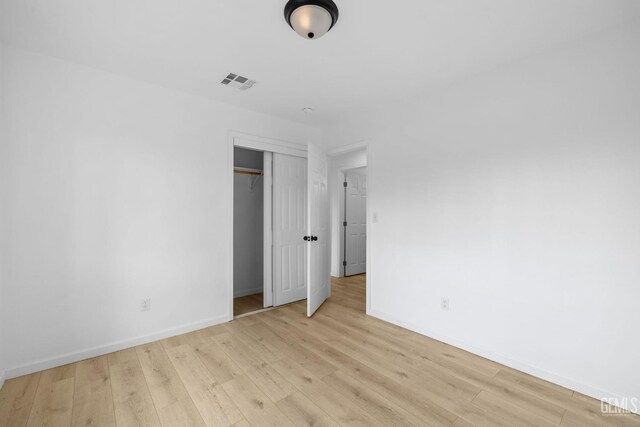 unfurnished bedroom featuring light hardwood / wood-style floors and a closet