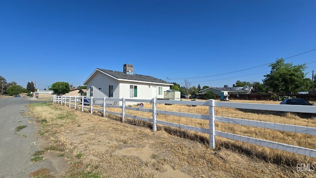 6304 Stanley St, Bakersfield, CA 93308 - view of side of property featuring stucco siding, a chimney, and fence