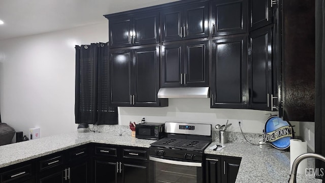 6304 Stanley St, Bakersfield, CA 93308 - kitchen featuring light stone counters, under cabinet range hood, gas stove, black microwave, and dark cabinetry