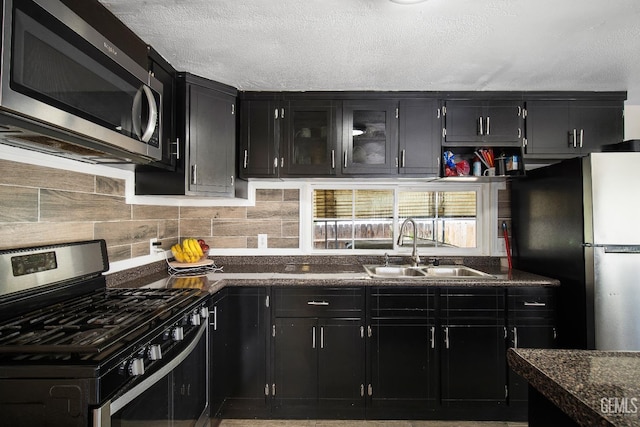 348 Petrol Rd Unit 394, Bakersfield, CA 93308 - kitchen with appliances with stainless steel finishes, dark cabinetry, dark countertops, backsplash, and a textured ceiling