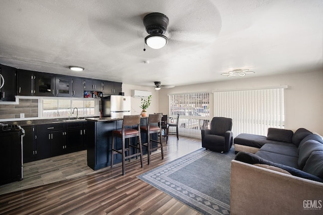 348 Petrol Rd Unit 394, Bakersfield, CA 93308 - kitchen featuring a ceiling fan, open floor plan, dark cabinetry, range with gas cooktop, and a textured ceiling