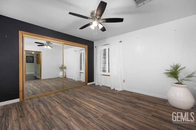 unfurnished bedroom with baseboards, wood finished floors, and visible vents