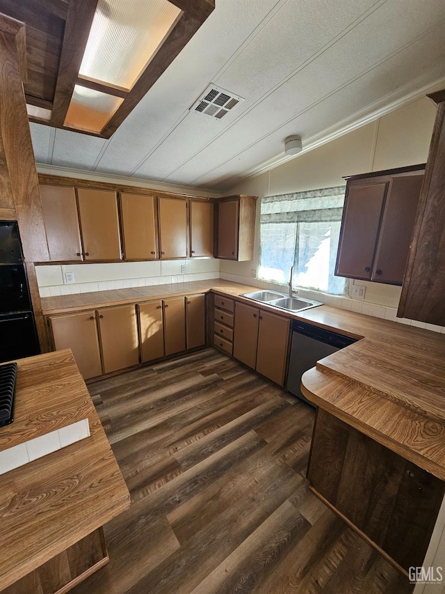 kitchen with vaulted ceiling, dishwasher, sink, and dark hardwood / wood-style floors