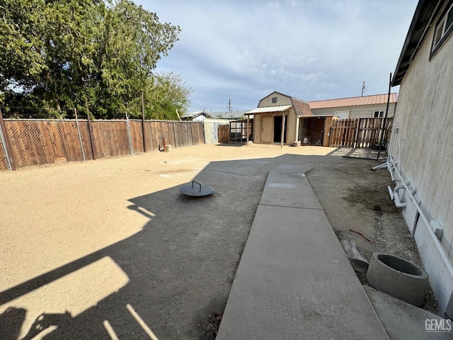 view of yard with an outbuilding, a fenced backyard, and a shed