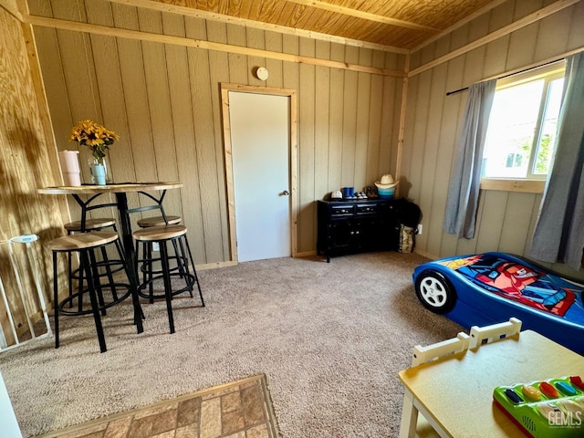 carpeted bedroom featuring wood walls