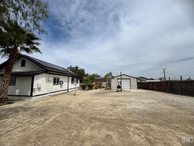 view of yard featuring an outbuilding, a garage, and fence
