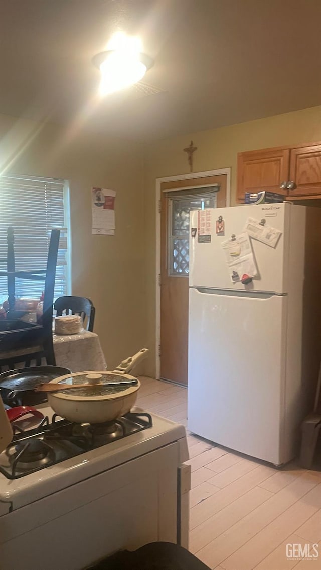 8300 Lexington Ave, Bakersfield, CA 93306 - kitchen with freestanding refrigerator, gas range oven, and light wood finished floors