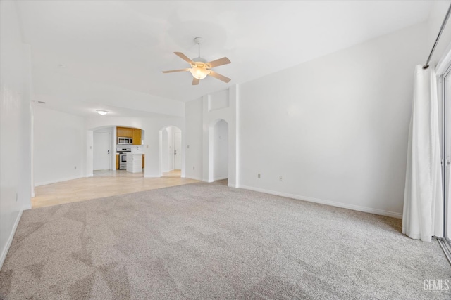 5820 Siena Ln, Bakersfield, CA 93308 - unfurnished living room featuring arched walkways, light colored carpet, ceiling fan, and baseboards