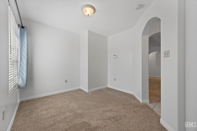 5820 Siena Ln, Bakersfield, CA 93308 - carpeted spare room featuring arched walkways, baseboards, a smoke detector, and tile patterned flooring