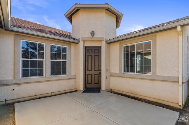 view of exterior entry featuring a patio