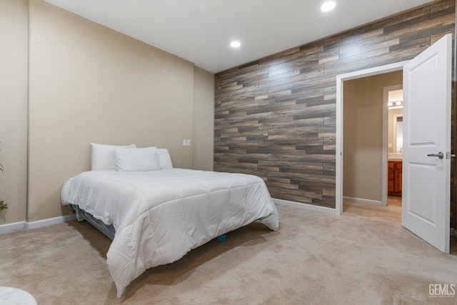 bedroom with light colored carpet and wood walls