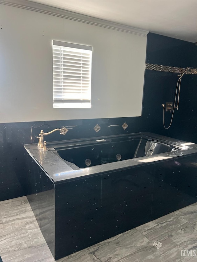 interior space with ornamental molding and a jetted tub