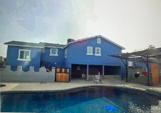 back of house with a patio, a pergola, and an outdoor pool
