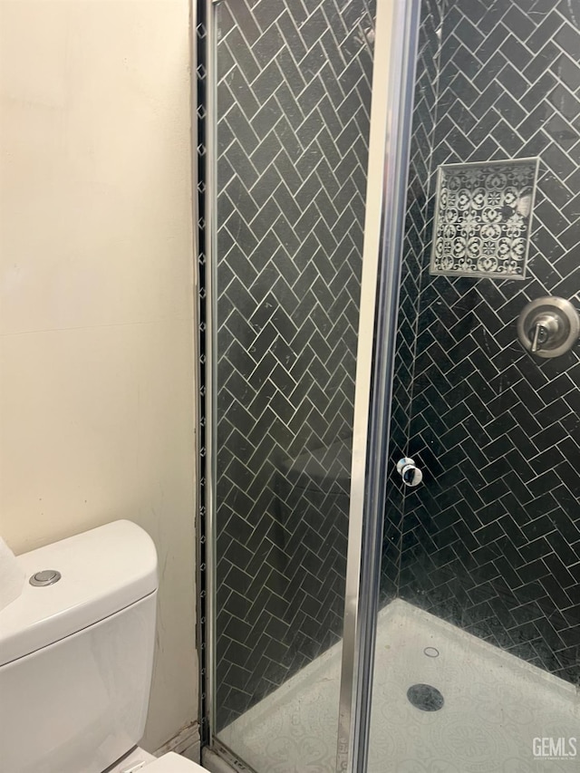full bathroom featuring toilet and a stall shower