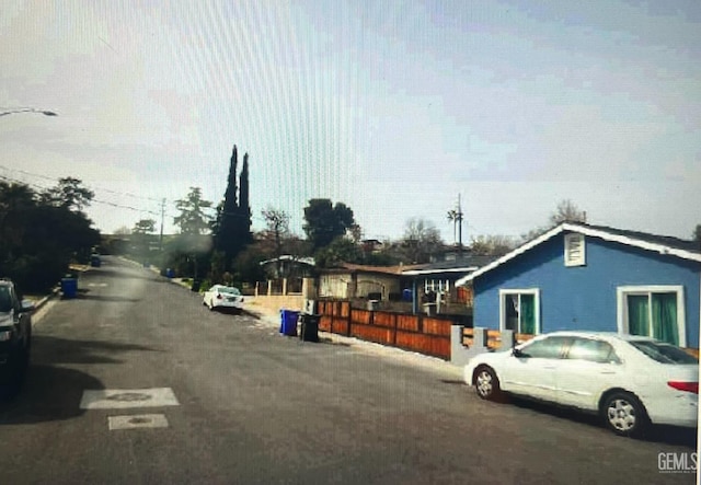 view of road featuring street lighting and curbs