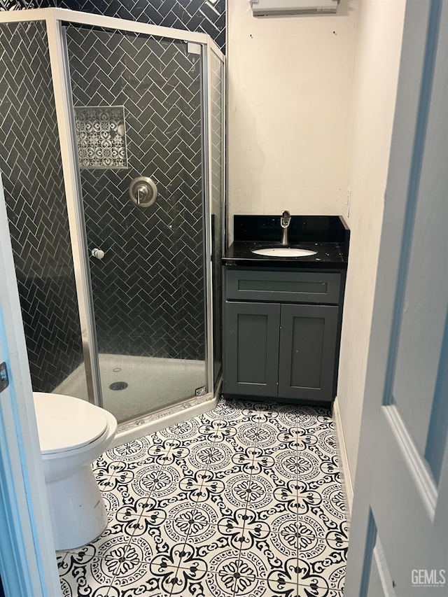 bathroom with vanity, tile patterned flooring, toilet, and a shower stall