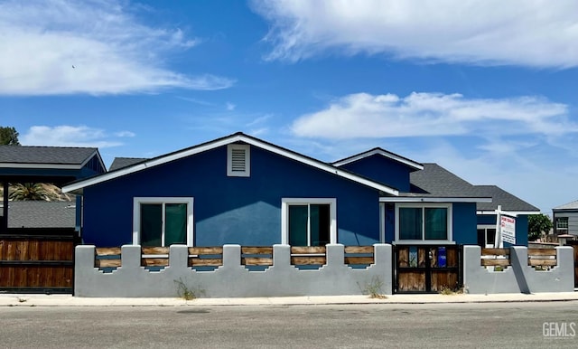 view of front facade with a fenced front yard and stucco siding
