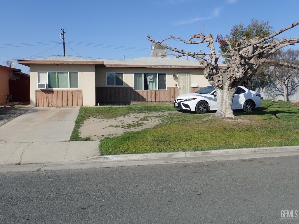 ranch-style house with cooling unit, fence, a front lawn, and stucco siding