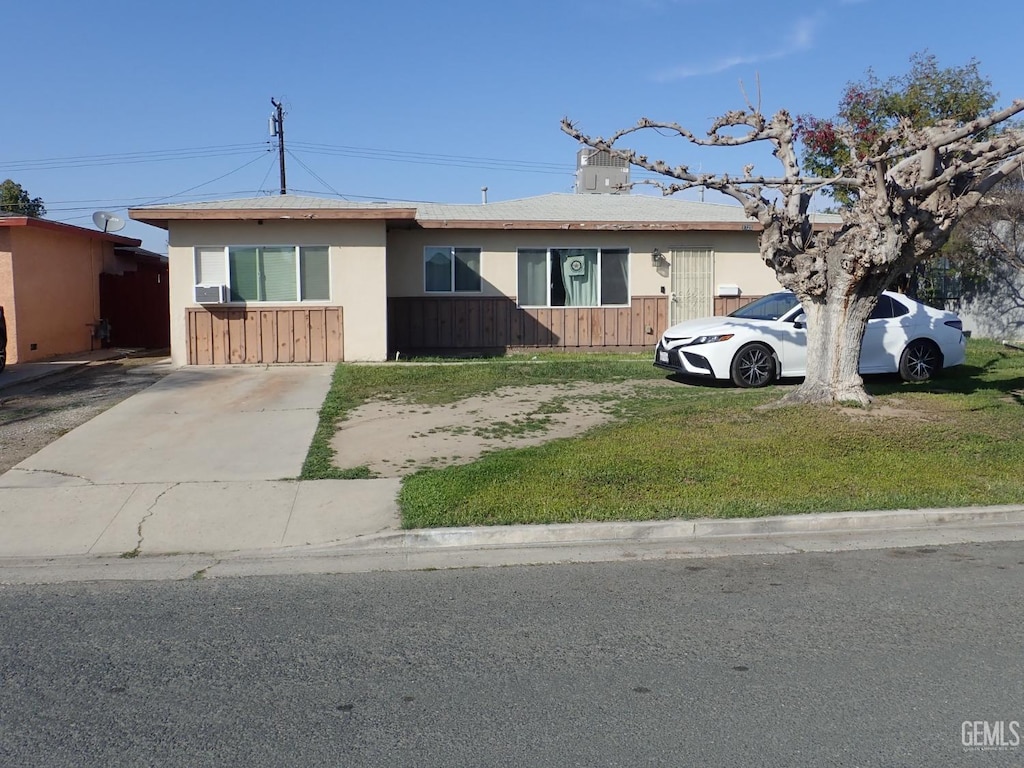 ranch-style home featuring a front lawn and fence