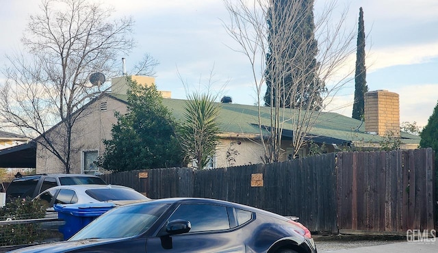 exterior space featuring a chimney and fence