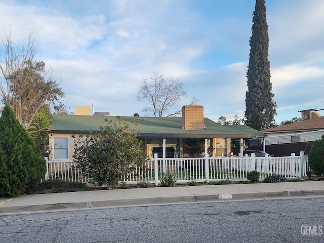 view of front of home featuring a fenced front yard and a chimney