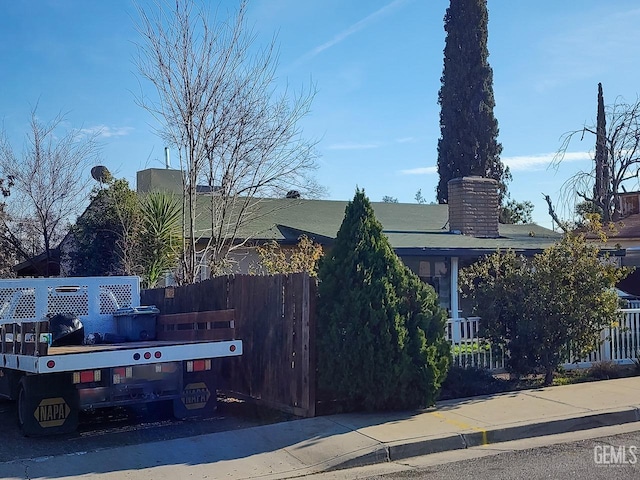 view of home's exterior with a chimney and fence