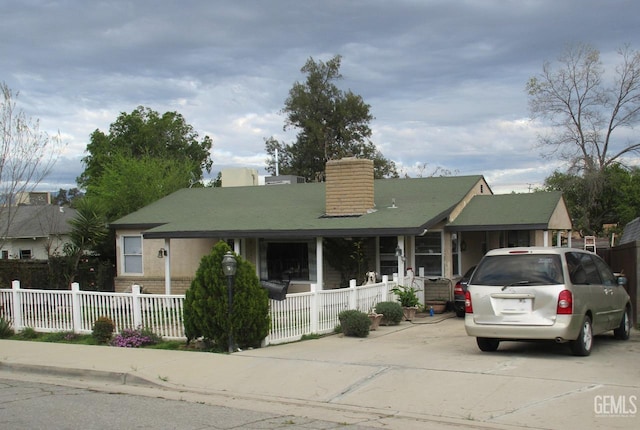 view of front of home featuring a fenced front yard and a chimney