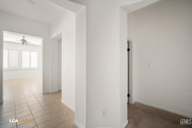 hallway featuring baseboards and light tile patterned floors