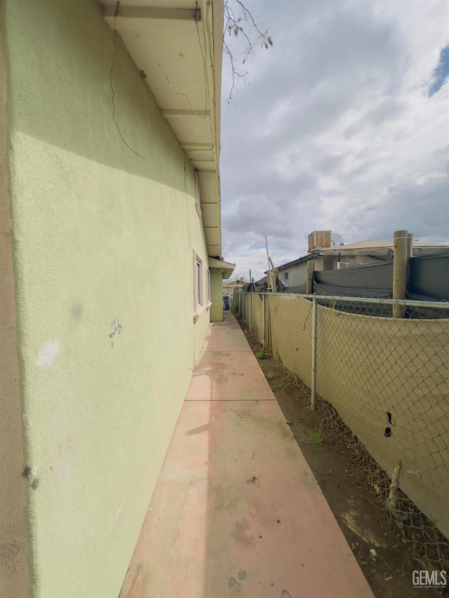 view of property exterior featuring stucco siding and fence