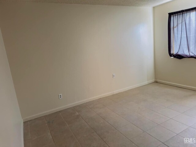 empty room featuring baseboards and a textured ceiling