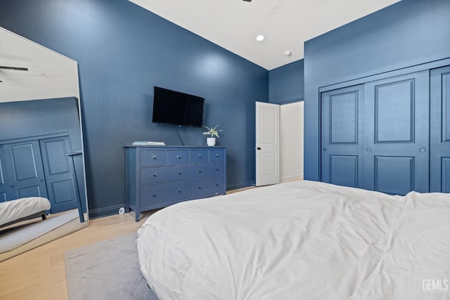 bedroom featuring ceiling fan, light hardwood / wood-style flooring, and vaulted ceiling