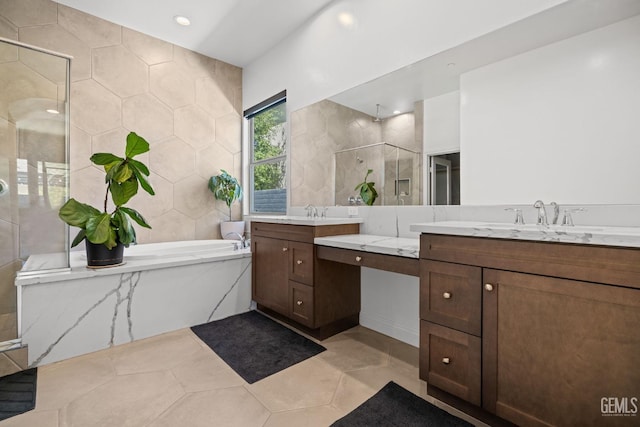 bathroom featuring tile patterned flooring, shower with separate bathtub, vanity, and tile walls