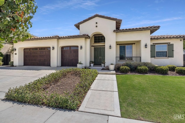 mediterranean / spanish house with a porch, a garage, and a front lawn