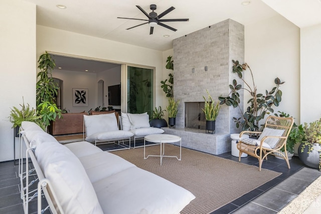 living room featuring ceiling fan and an outdoor brick fireplace