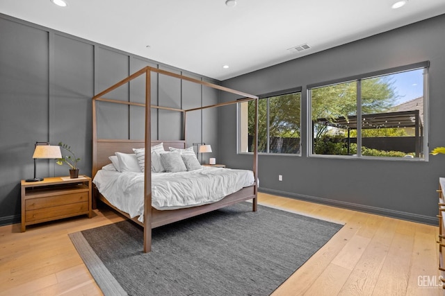 bedroom with multiple windows and light wood-type flooring