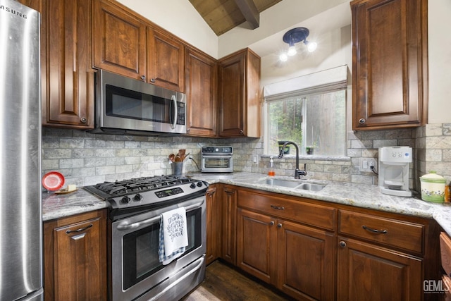 kitchen with sink, decorative backsplash, light stone countertops, and appliances with stainless steel finishes