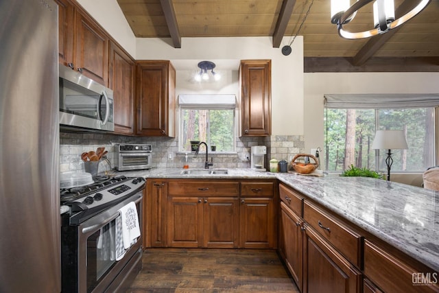 kitchen featuring light stone counters, sink, backsplash, and stainless steel appliances