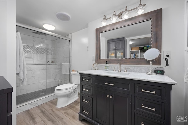 bathroom featuring walk in shower, vanity, toilet, and hardwood / wood-style floors