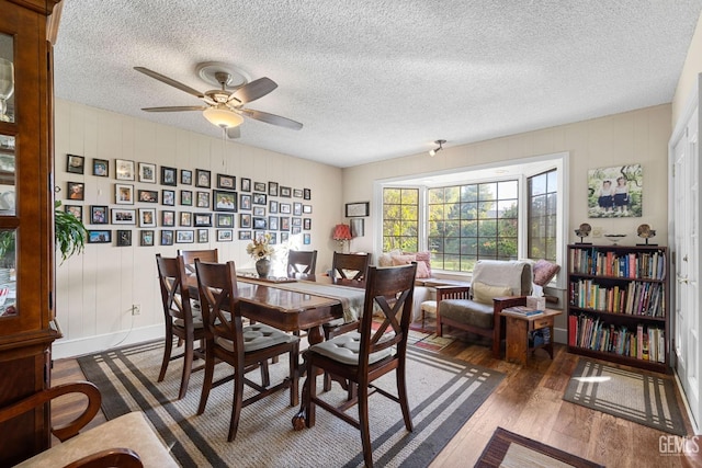 dining area with dark hardwood / wood-style floors, ceiling fan, and a textured ceiling