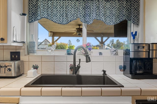 kitchen featuring tasteful backsplash, tile countertops, ceiling fan, and sink