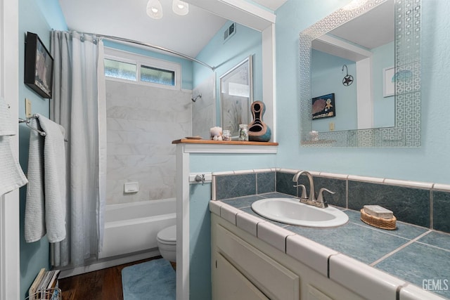 full bathroom featuring hardwood / wood-style flooring, vanity, toilet, and shower / tub combo