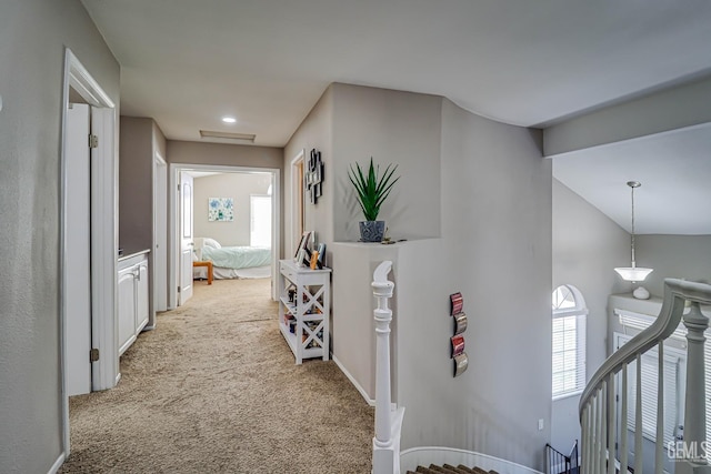 hall with light carpet and vaulted ceiling