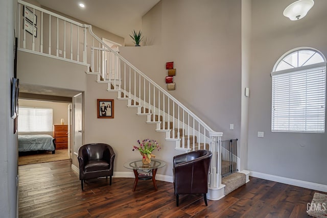 stairs featuring wood-type flooring and a high ceiling