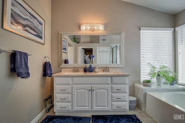 bathroom featuring a bathing tub, vanity, tile patterned floors, and lofted ceiling